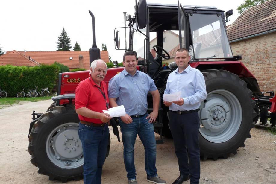 A 3 település polgármestere a beszerzett MTZ traktorral a háttérben